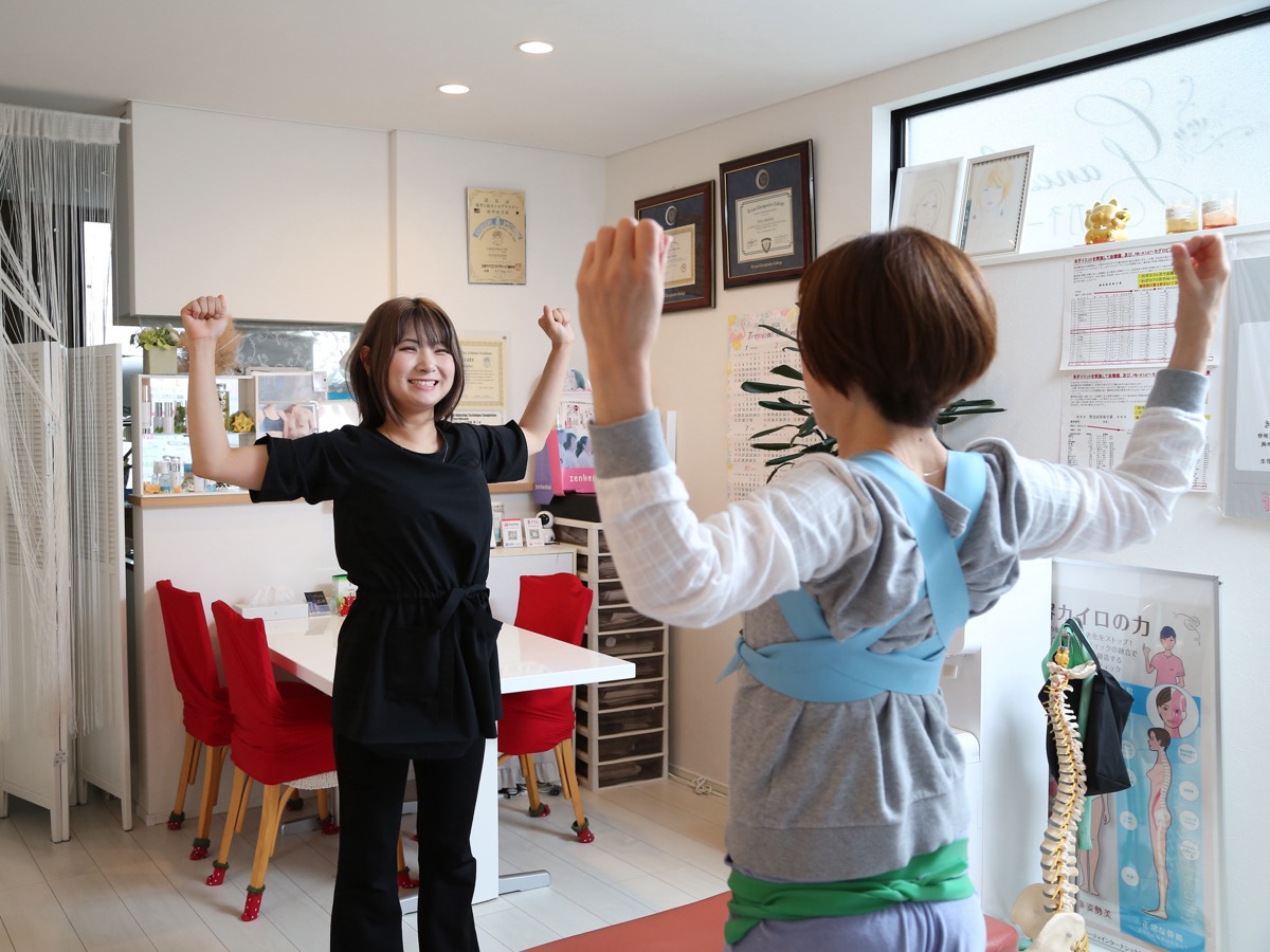 スタッフとお客さまが一緒に両腕を上げて体操する様子